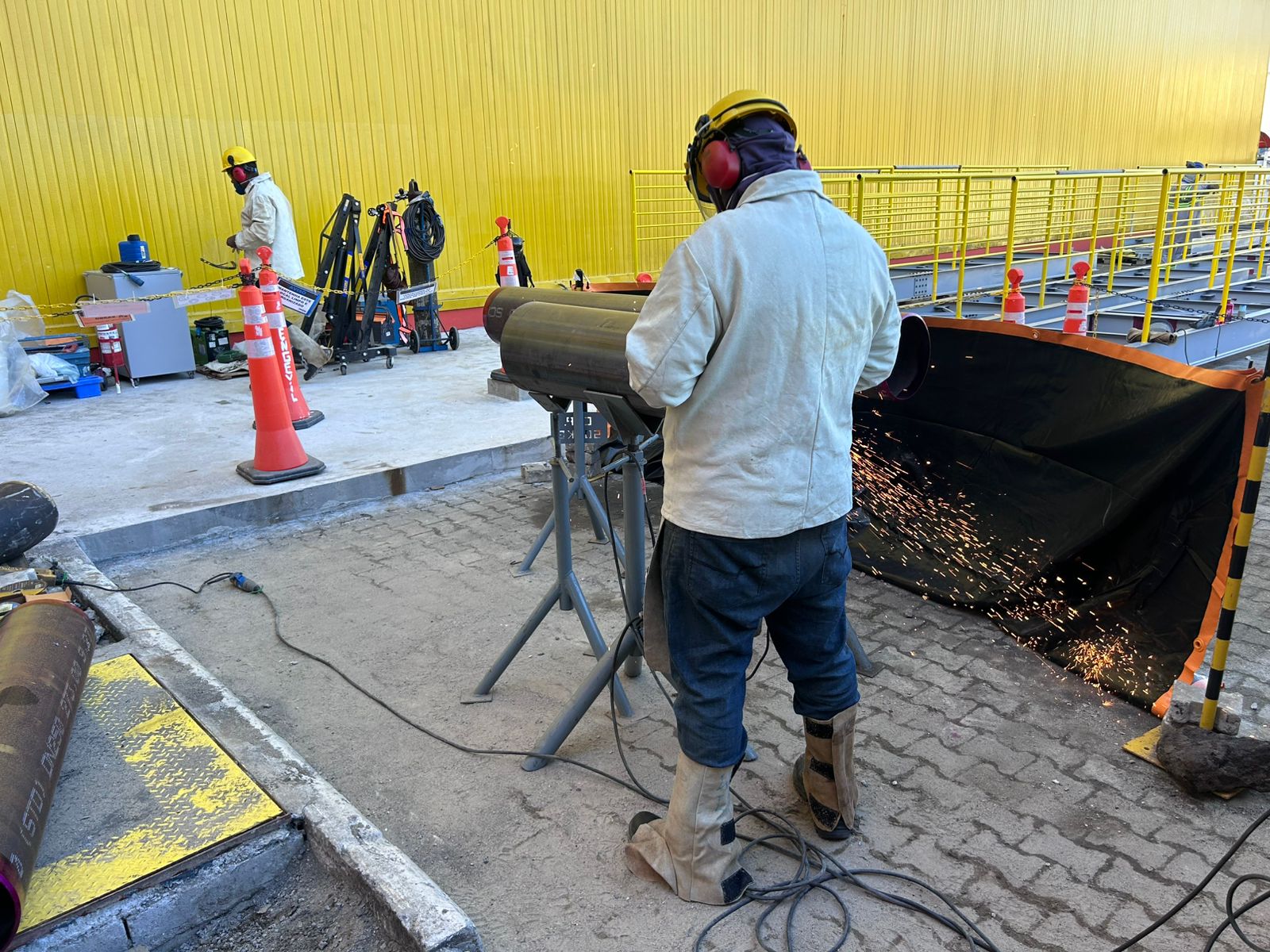 Profissional cortando tubulação na fábrica da Garoto